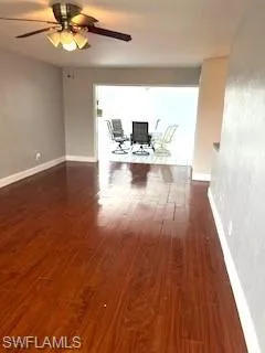 Unfurnished living room with wood finished floors and ceiling fan