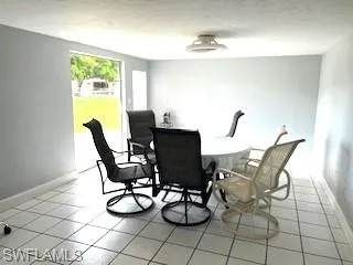 Dining area with light tile patterned flooring and a textured ceiling