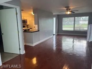 Unfurnished living room featuring wood finished floors and ceiling fan