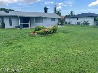 Rear view of property with a lawn