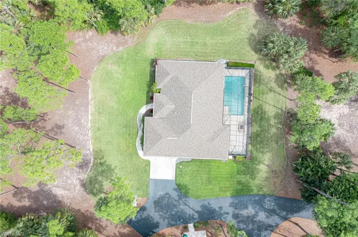 View of home, pool, manicured yard & driveway