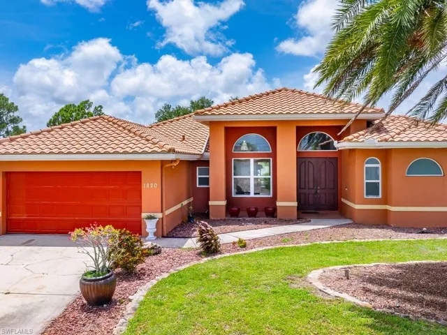 View of front of home with a garage and a front lawn