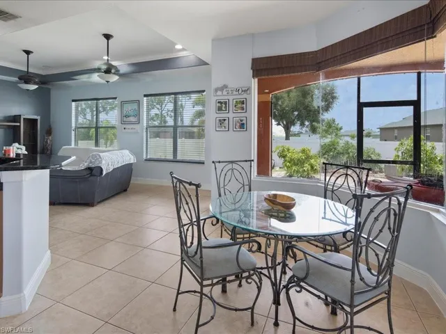 Tiled dining area featuring ceiling fan and a raised ceiling