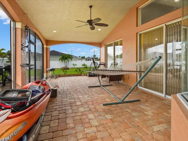 View of patio with ceiling fan and glass enclosure
