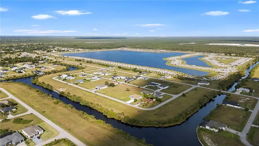 Aerial view of property's location featuring a nearby body of water and a heavily wooded area