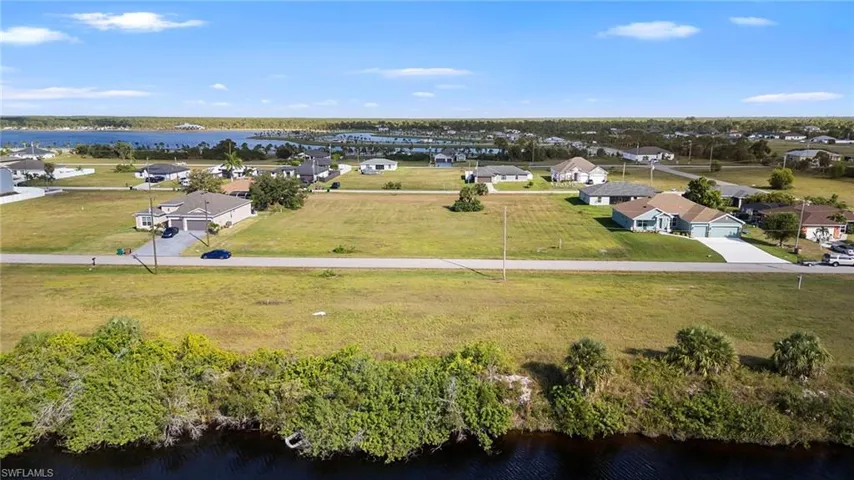 Aerial perspective of suburban area featuring a nearby body of water