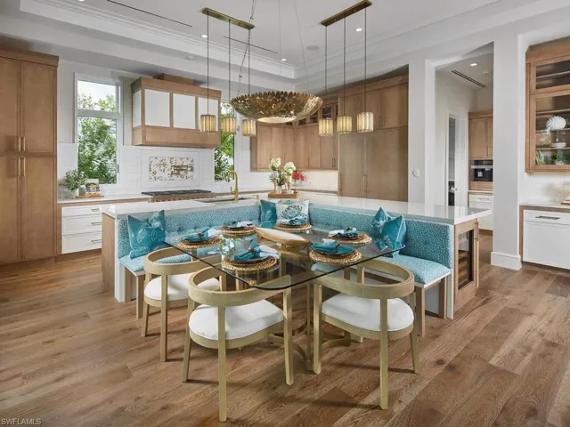 Dining area featuring a tray ceiling, light hardwood / wood-style floors, sink, and crown molding
