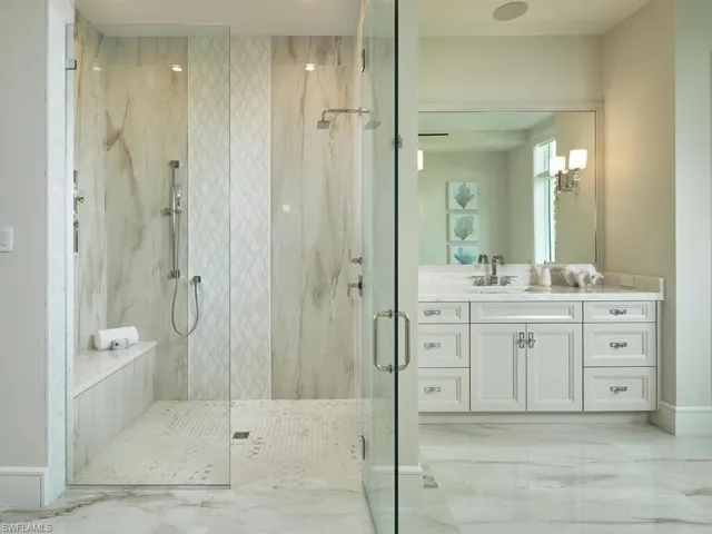 Bathroom with an enclosed shower, tile flooring, and vanity with extensive cabinet space
