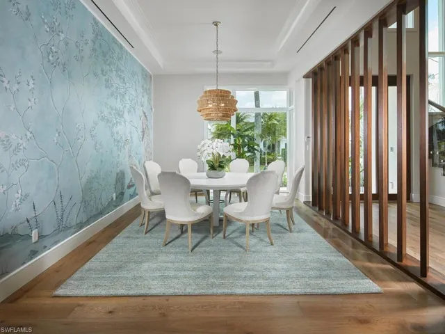 Dining space with a tray ceiling and dark wood-type flooring