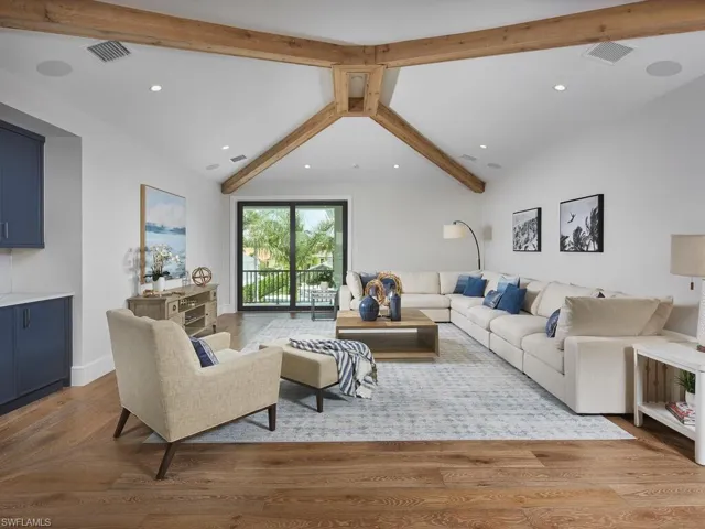 Living room with vaulted ceiling with beams and wood-type flooring