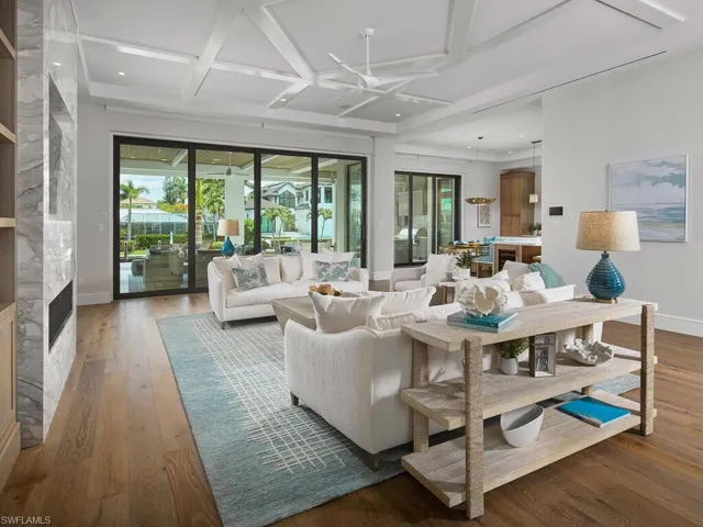 Living room featuring hardwood / wood-style floors, coffered ceiling, and a high end fireplace