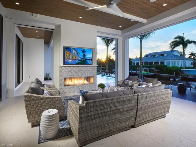 Patio terrace at dusk with ceiling fan and an outdoor living space with a fireplace
