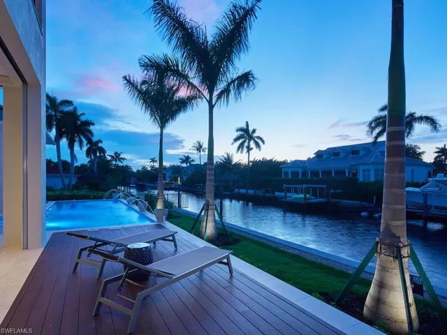 Deck at dusk featuring a water view and a dock
