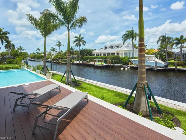 Wooden deck with a boat dock and a water view