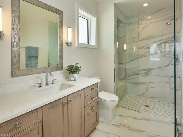 Bathroom with tile flooring, an enclosed shower, toilet, and vanity