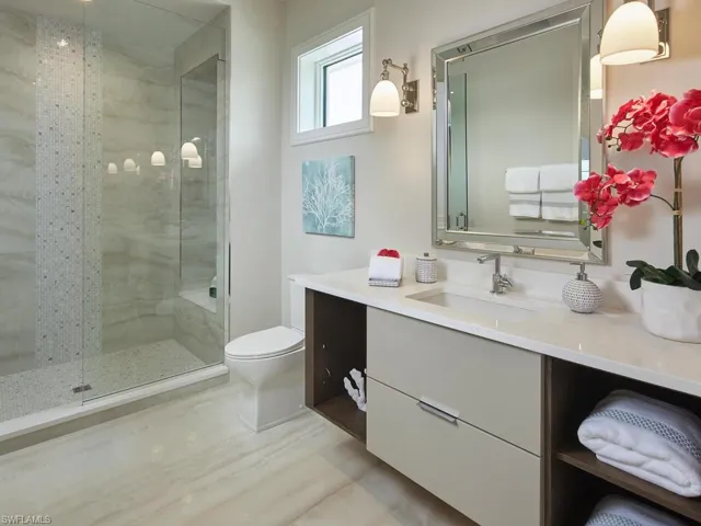 Bathroom featuring tile floors, an enclosed shower, vanity, and toilet