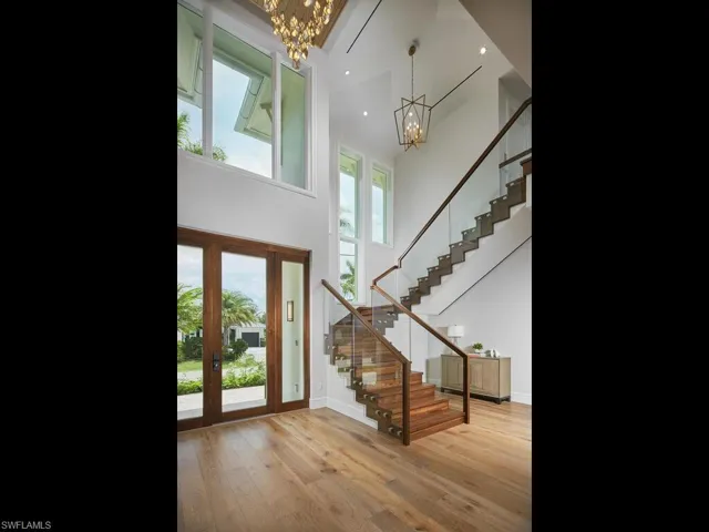 Foyer entrance with an inviting chandelier, a high ceiling, and hardwood / wood-style flooring