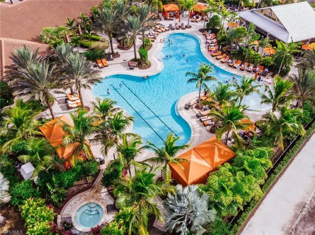 Expansive Community  amenities featuring a large freeform pool, a circular spa, lush tropical landscaping, and one of three resort restaurants