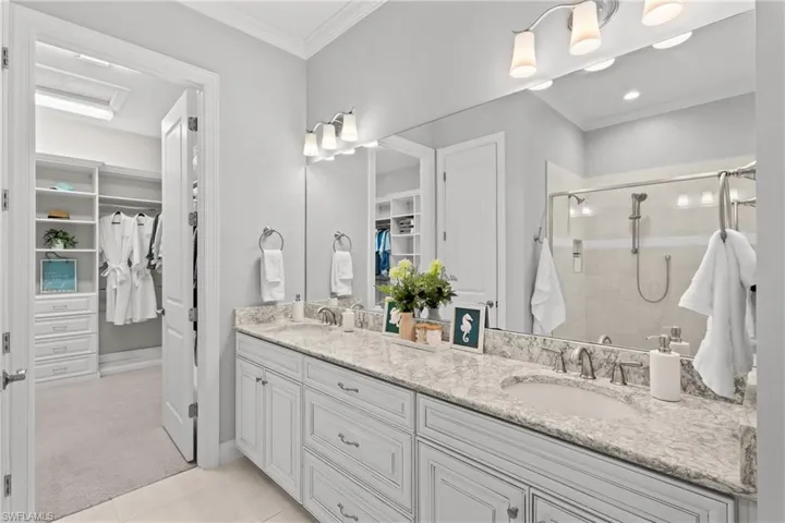 Double vanity with undermount sinks, stone countertop, and individual vanity lighting