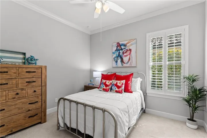 Crown molding accentuating light gray walls, with a white ceiling fan and recessed lighting