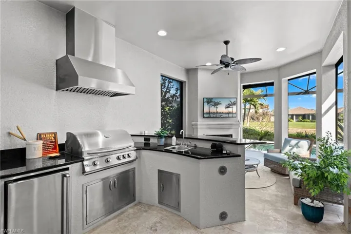 Outdoor kitchen with gas grill, fridge and granite counters