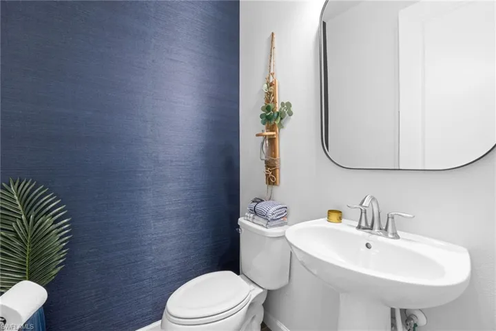 Bathroom with toilet and wallpapered walls