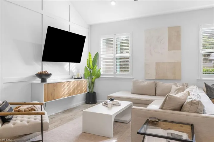 Living area with wood finished floors and vaulted ceiling