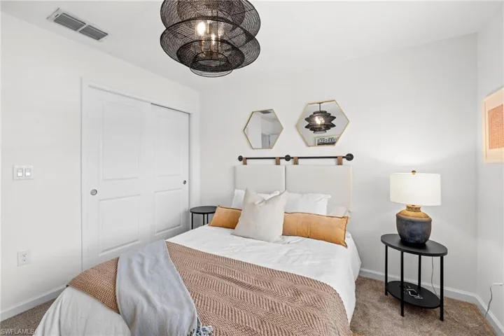 Carpeted bedroom with baseboards and a closet