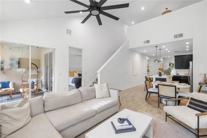 Living area with light wood finished floors, recessed lighting, lofted ceiling, and a ceiling fan