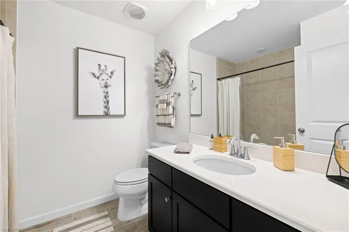 Bathroom featuring vanity, curtained shower, and wood finish floors