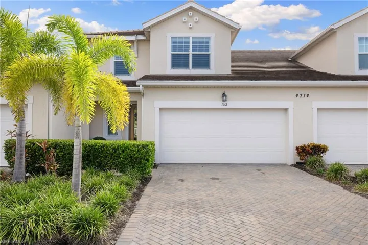 View of front of home with stucco siding, decorative driveway, and an attached garage