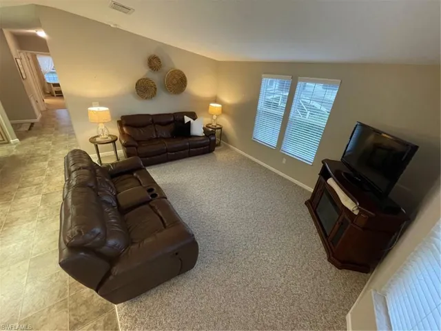 Living room featuring tile floors and lofted ceiling