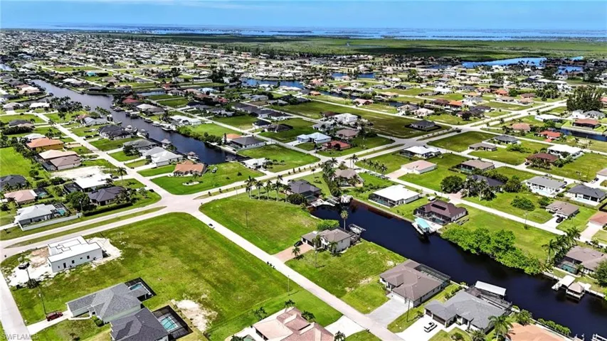 Aerial perspective of suburban area featuring a nearby body of water