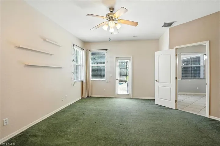 Carpeted empty room featuring healthy amount of natural light and ceiling fan