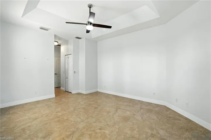 Spare room featuring a ceiling fan and a tray ceiling