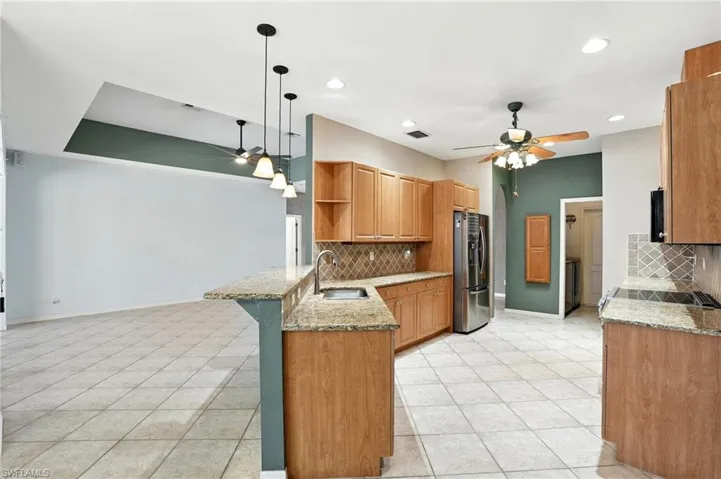 Kitchen featuring ceiling fan, a peninsula, backsplash, open shelves, and recessed lighting