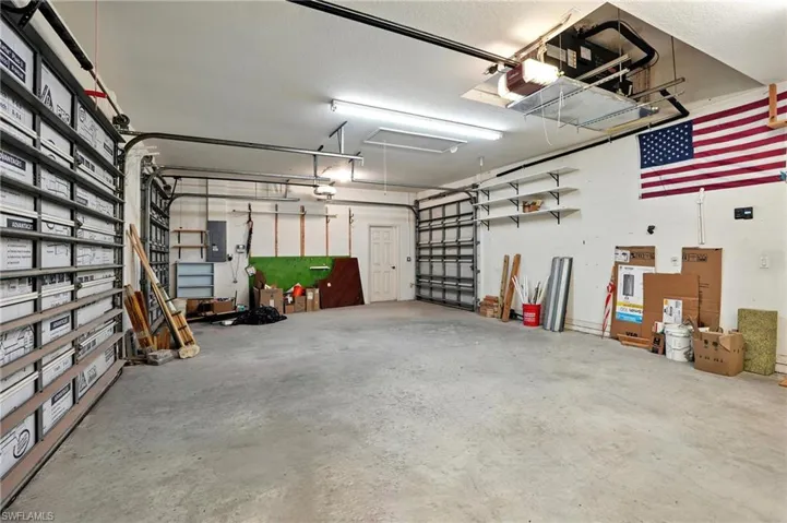 Garage featuring electric panel and a garage door opener