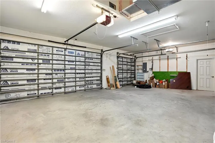 Garage featuring a garage door opener and electric panel