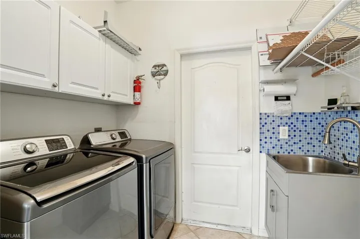 Laundry room featuring cabinet space, independent washer and dryer, and light tile patterned floors