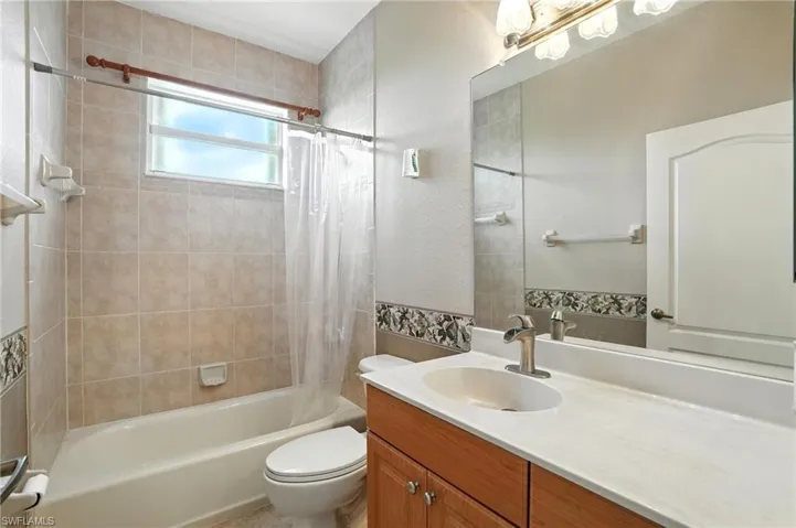 Bathroom with shower / tub combo with curtain and vanity