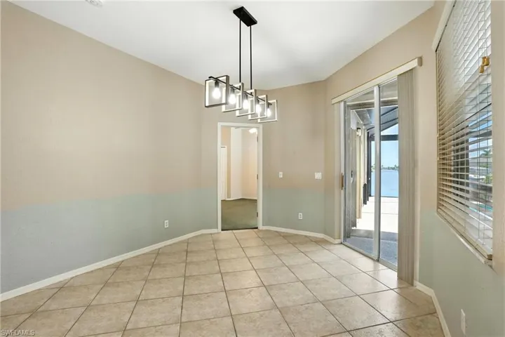 Unfurnished dining area with light tile patterned floors and a chandelier