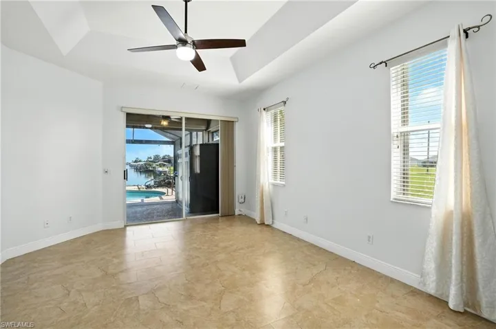 Unfurnished room with a raised ceiling, a sunroom, and a ceiling fan