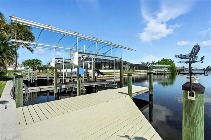 Dock area featuring boat lift and a water view