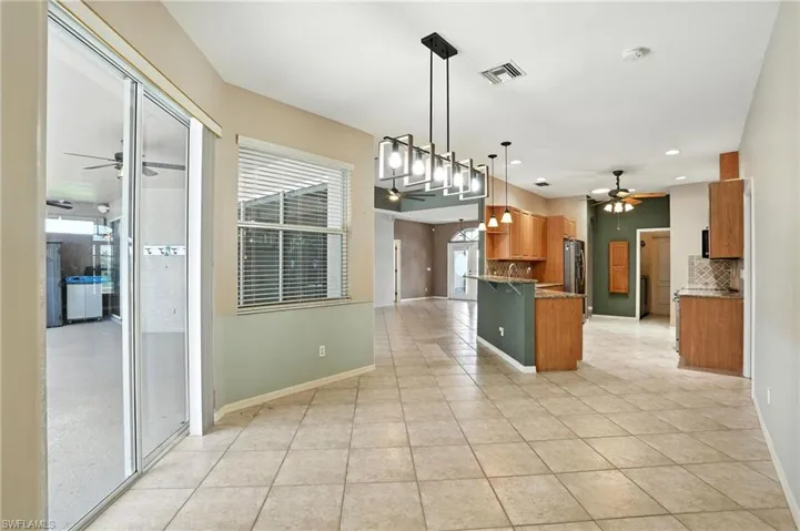 Kitchen featuring ceiling fan, light tile patterned floors, tasteful backsplash, brown cabinets, and recessed lighting