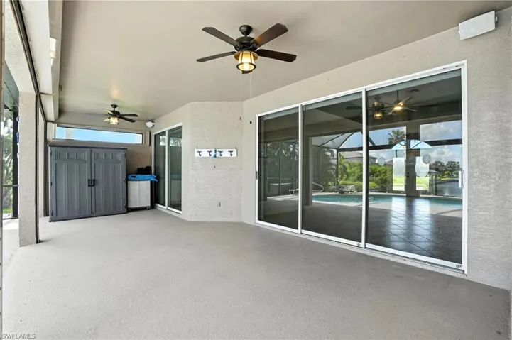 View of patio with ceiling fan and an outdoor pool