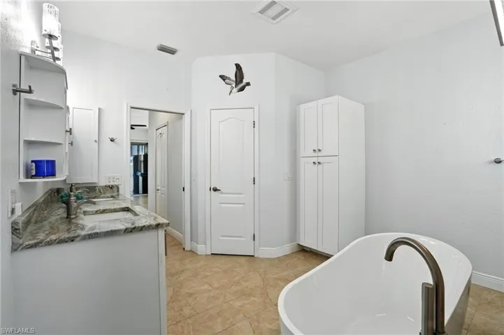 Bathroom featuring vanity and a soaking tub
