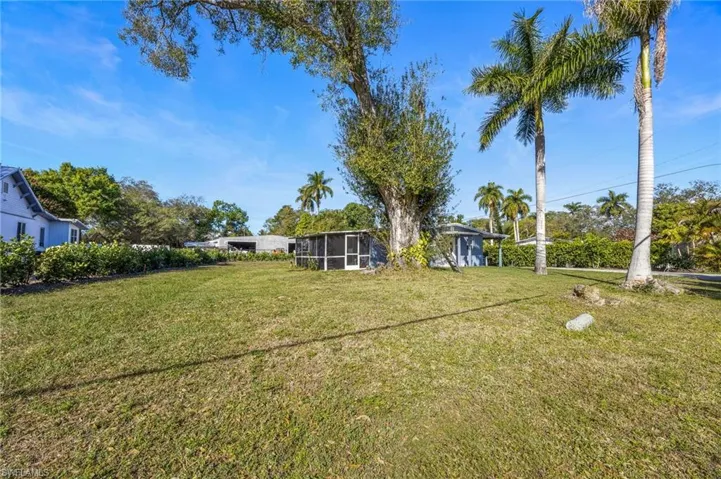 View of grassy yard with a sunroom
