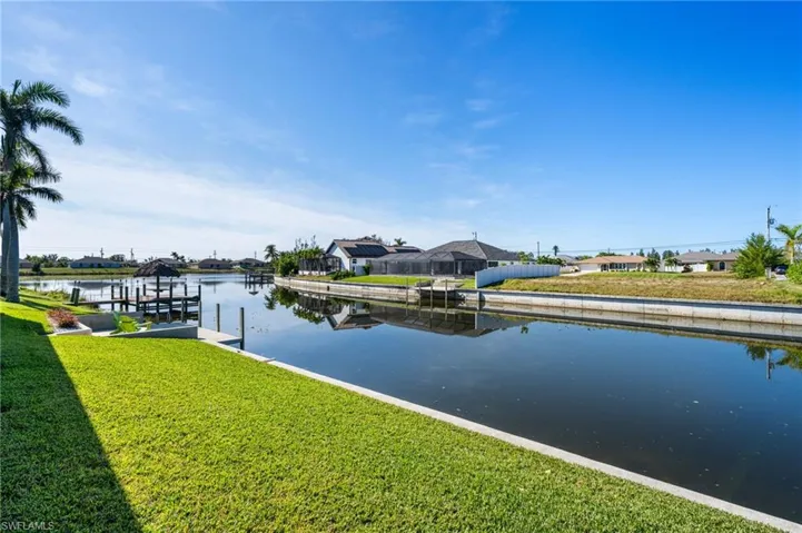 View of dock with a yard and a water view