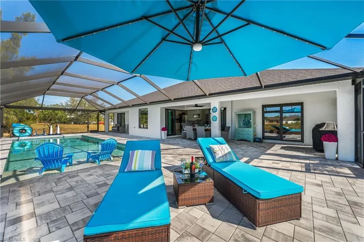 View of patio featuring glass enclosure, ceiling fan, and sink