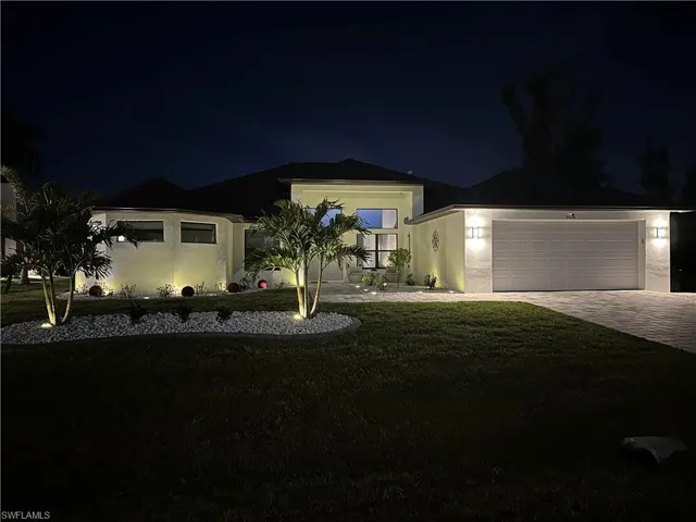 View of front of property featuring a yard and a garage